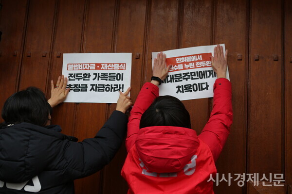 서대문지역 제 단체 회원들이 26일 오후 3시 서울 서대문구 연희동 제11·12대 대통령을 지낸 전두환 전대통령 사저 대문에 규탄글을 붙이고 있다. 사진=김주현 기자
