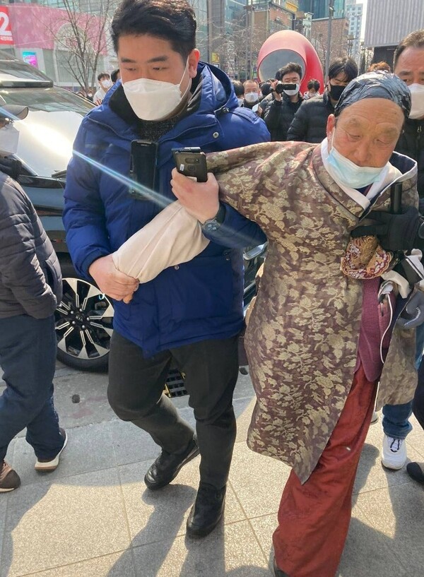 민주당 관계자가 송 대표에게 망치를 휘두른 한 노인의 팔을 붙잡고 유세장 밖으로 끌어내고 있다. 사진=민주당