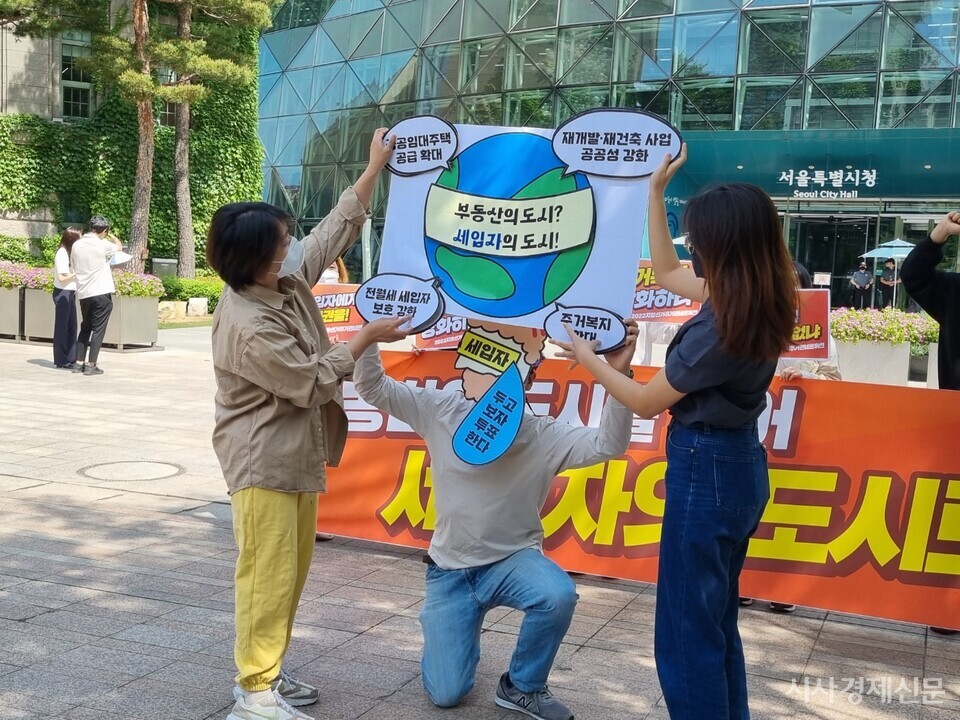 지방선거주거권네트워크가 12일 서울시청 앞에서 열린 출범기자회견에서 세입자에게 '주거복지 확대' 라고 적힌 스티커를 붙여 '세입자의 도시'를 만든다는 내용의 퍼포먼스를 진행했다. 사진=박영신 기자