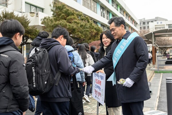 학교폭력예방 등굣길 합동 캠페인에 참여해 학생들에게 홍보물을 배부 중인 이기재 구청장. 사진=양천구