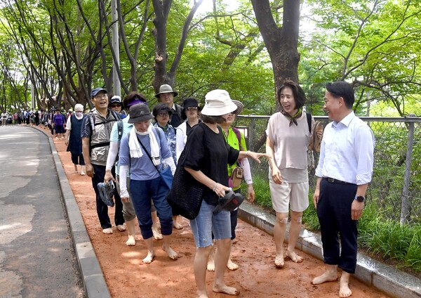 구민들과 함께 ‘안산 황톳길’을 맨발로 걷고 있는 이성헌 구청장. 사진=서대문구